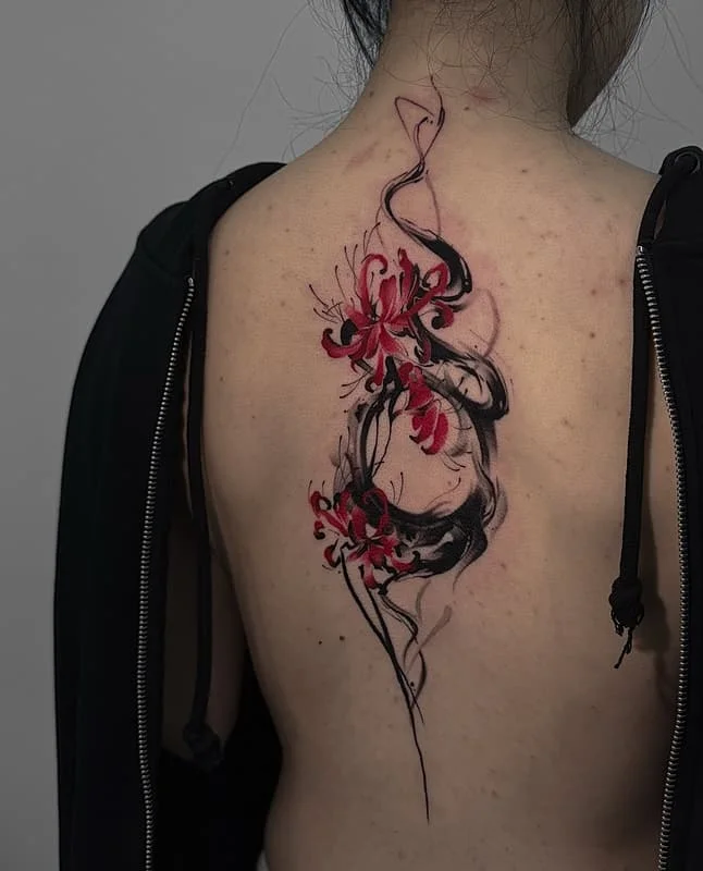 Colorful watercolor floral tattoo on a woman's back.