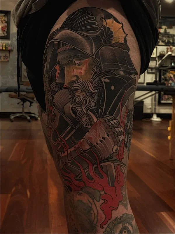 Detailed warrior tattoo on thigh with vibrant colors.