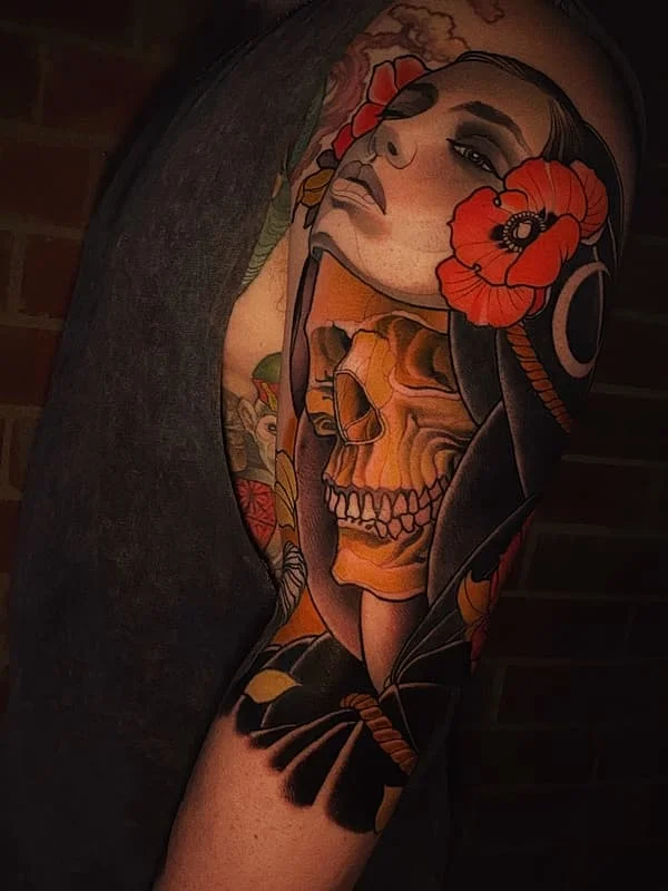 Colorful full-sleeve tattoo of a woman and skull with flowers.