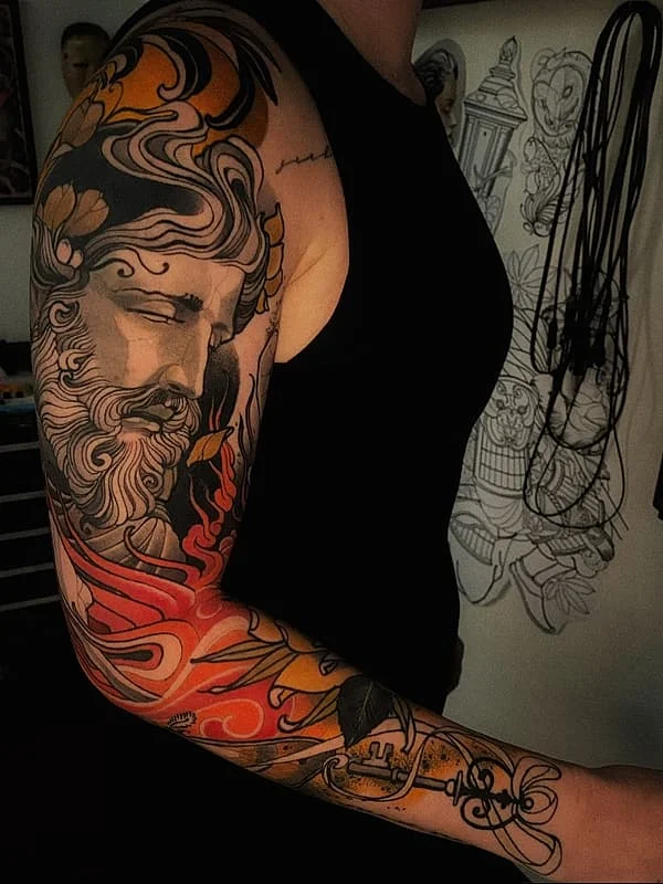 Full-sleeve tattoo of a mythical figure with floral designs.