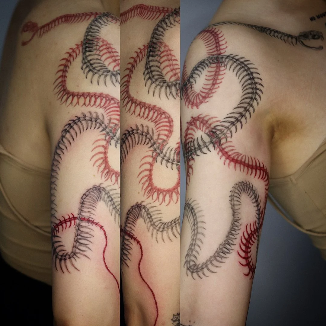 Large abstract snake tattoo on arm and shoulder.