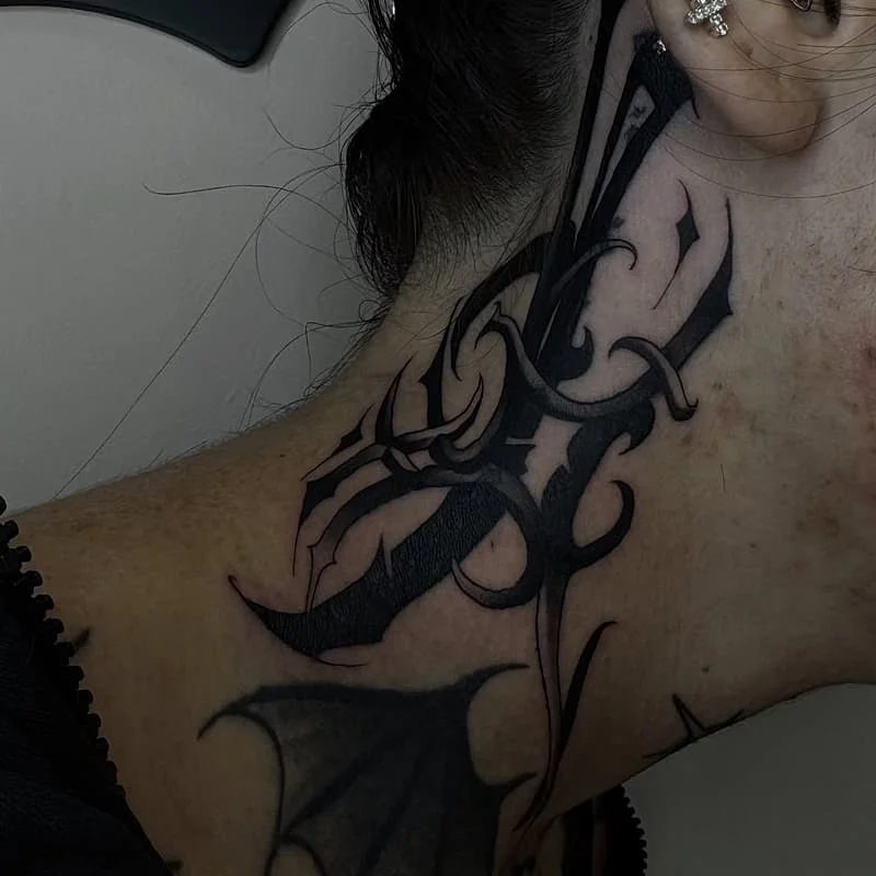 Intricate blackwork neck tattoo with tribal and floral elements.