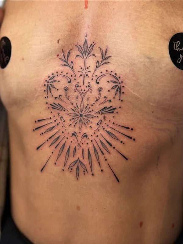 Intricate fine-line floral tattoo on chest.