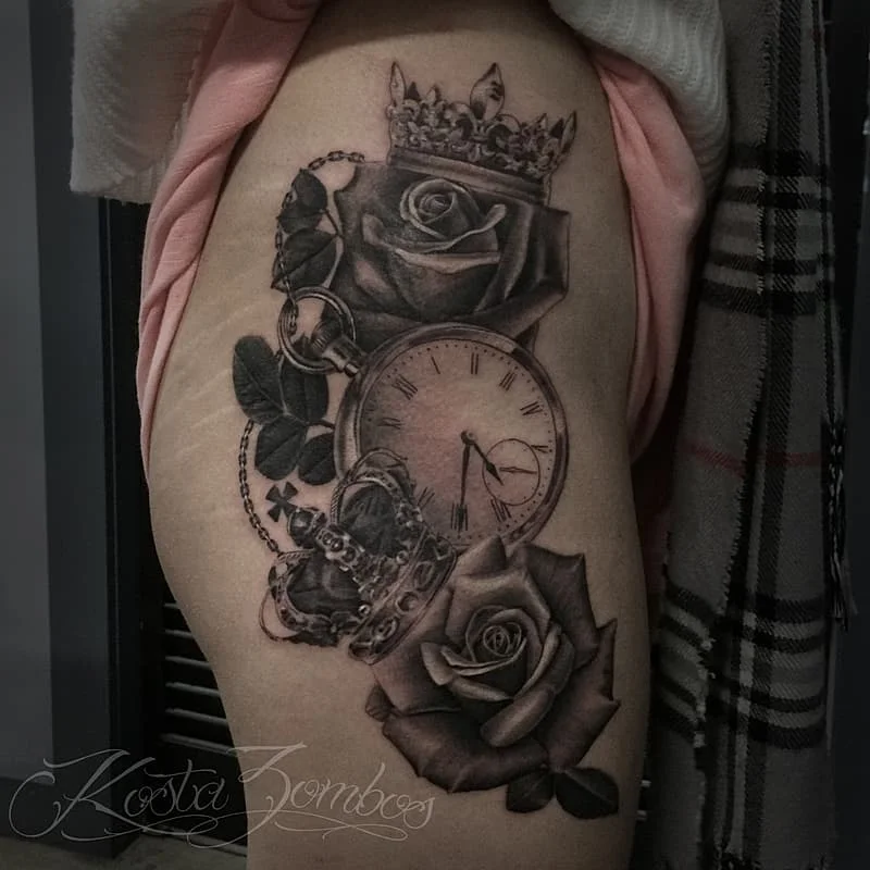 Black-and-grey tattoo of roses and clock on thigh.