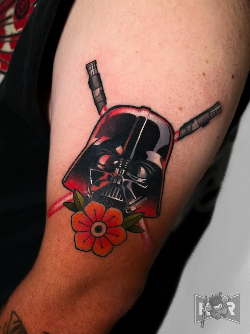 Colorful Darth Vader tattoo with a flower on the arm.