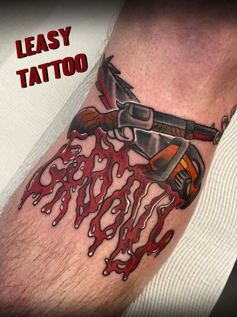 Colorful gun tattoo with blood on forearm.