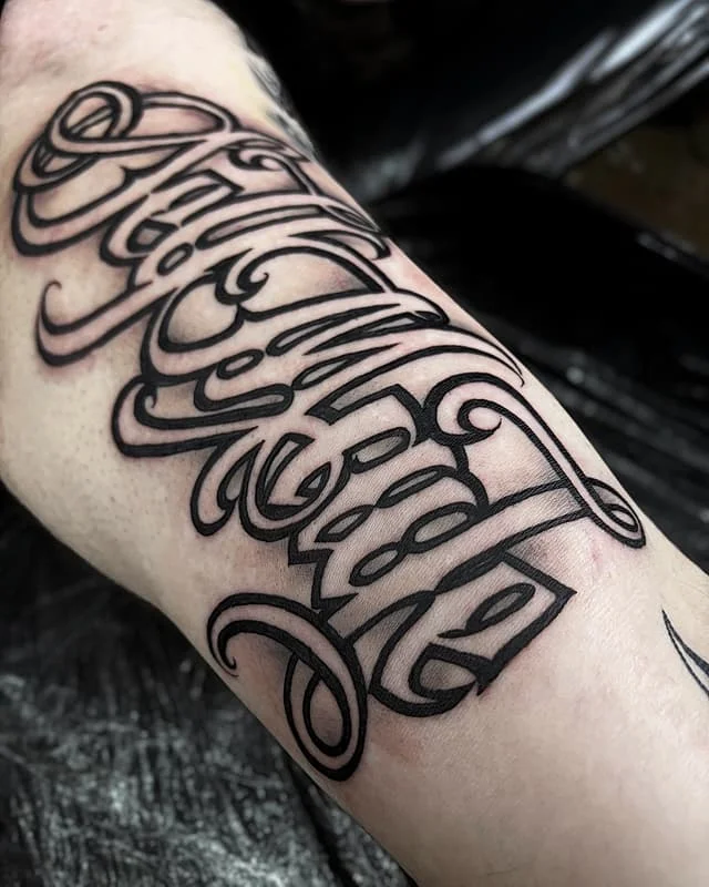 Medium-sized script tattoo on forearm in black-grey.