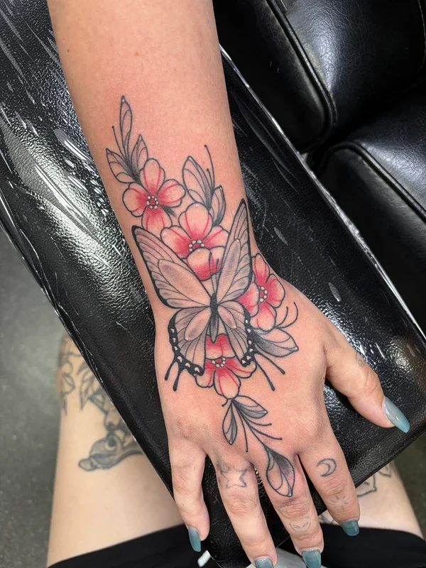 Illustrative butterfly and flower tattoo on hand.