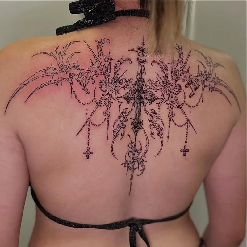 Large blackwork tattoo with ornate designs on back.