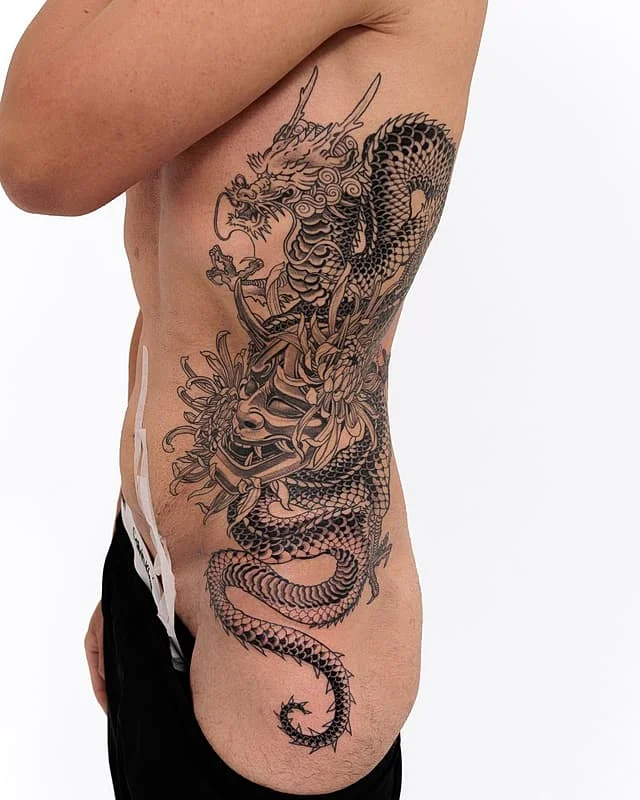 Large black-and-grey Japanese dragon tattoo on rib.