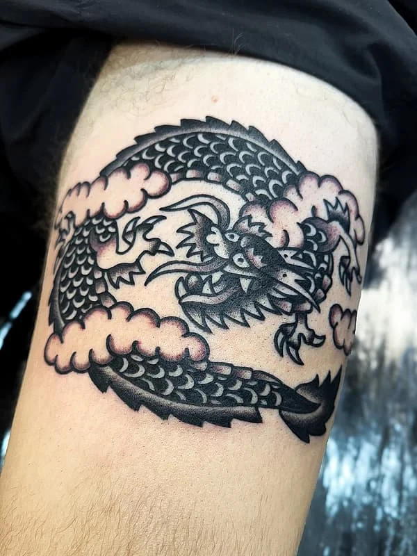 Japanese dragon tattoo on arm with clouds.