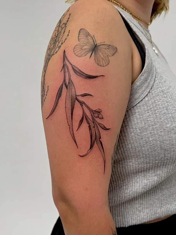Black and grey floral tattoo with butterfly on arm.