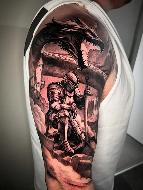 Large black-and-grey tattoo of a knight and dragon on arm.