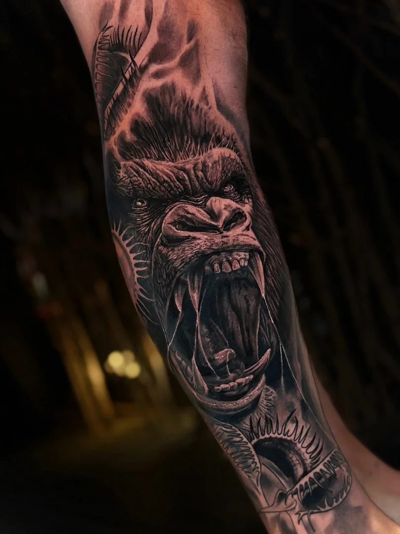 Realistic gorilla tattoo on forearm.