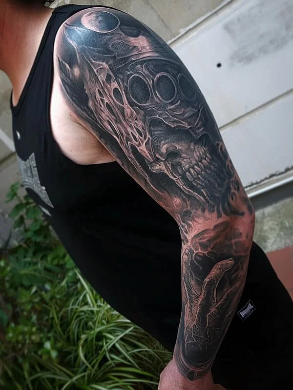 Detailed black-and-grey full-sleeve tattoo featuring a skull.