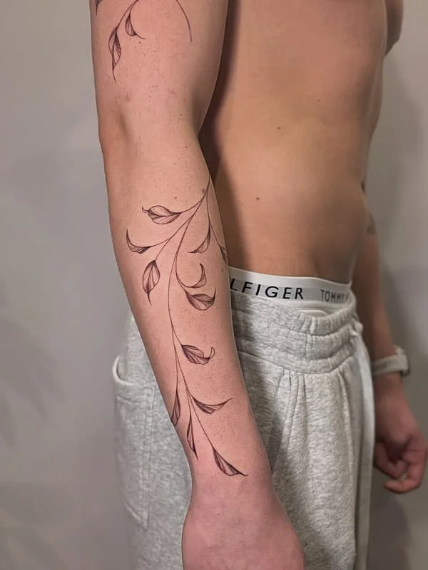 Fine-line floral tattoo on a man's arm.