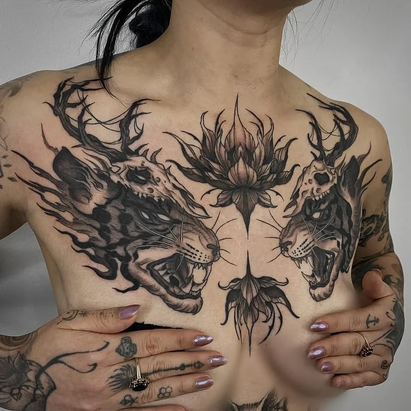 Black-and-grey chest tattoo of leopards and lotus flower.