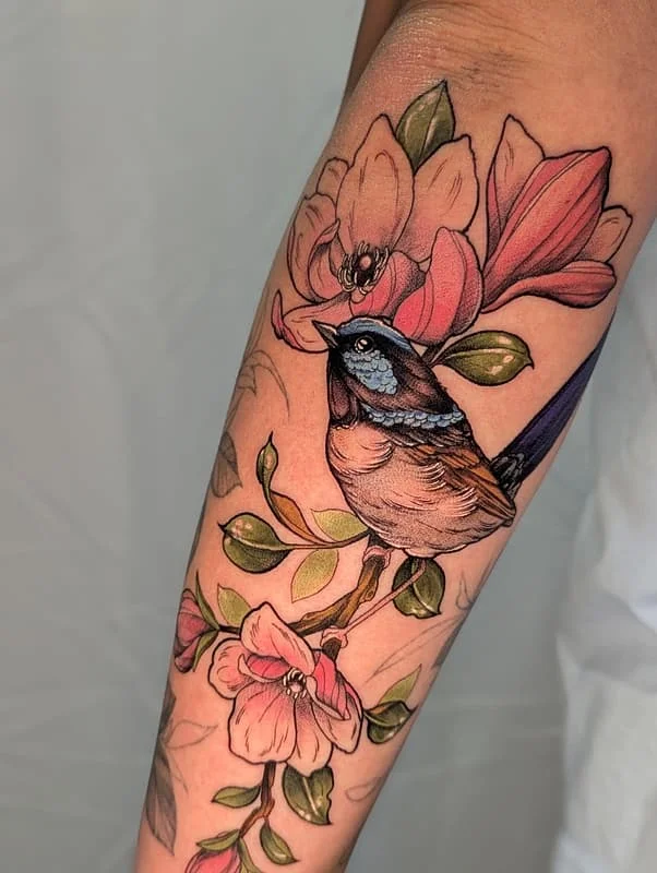 Colorful bird and floral tattoo on forearm.