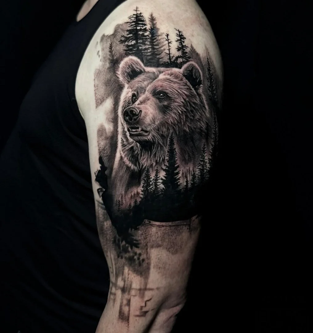 Realistic bear tattoo on the arm with forest background.