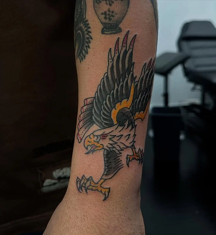 Traditional eagle tattoo on the arm in vibrant colors.