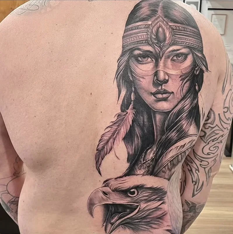 Large black-and-grey tattoo of a woman and eagle on back.