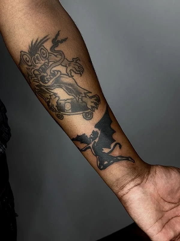 Forearm tattoo of a dragon and a demon.