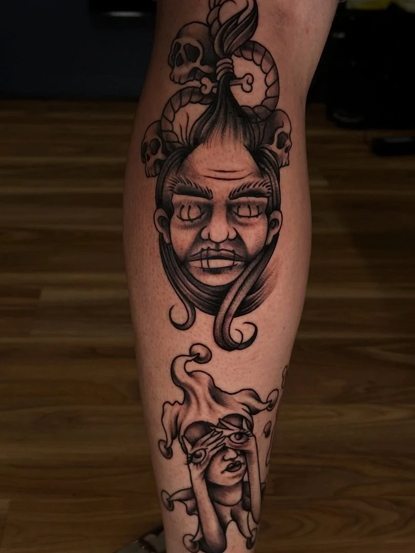 Illustrative blackwork tattoo on leg featuring character and skull.