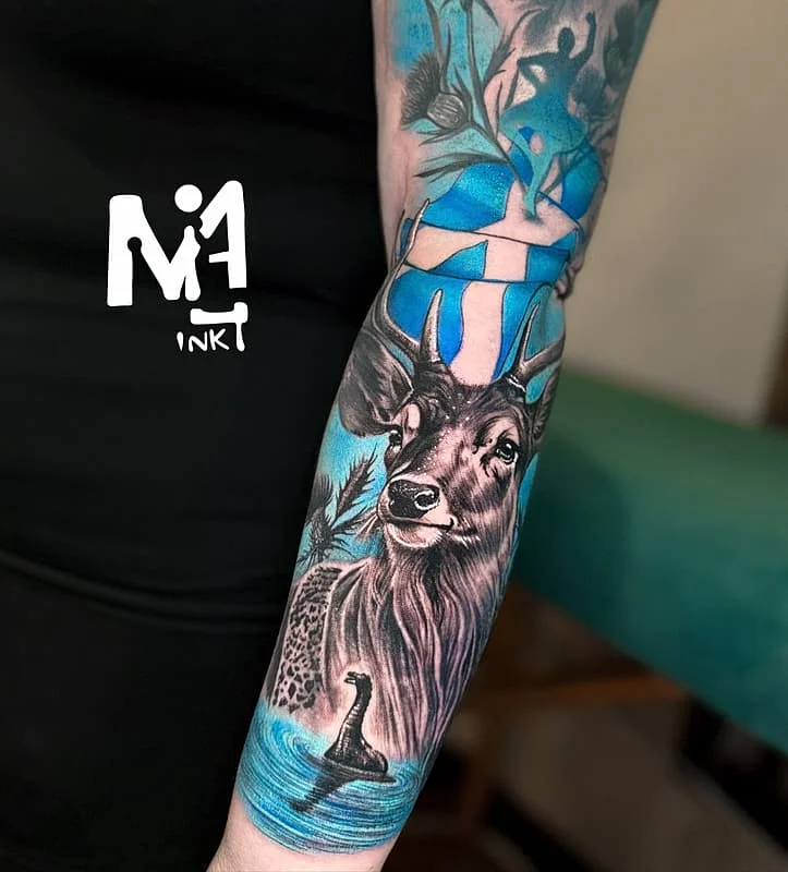Illustrative deer tattoo with watercolor elements on forearm.