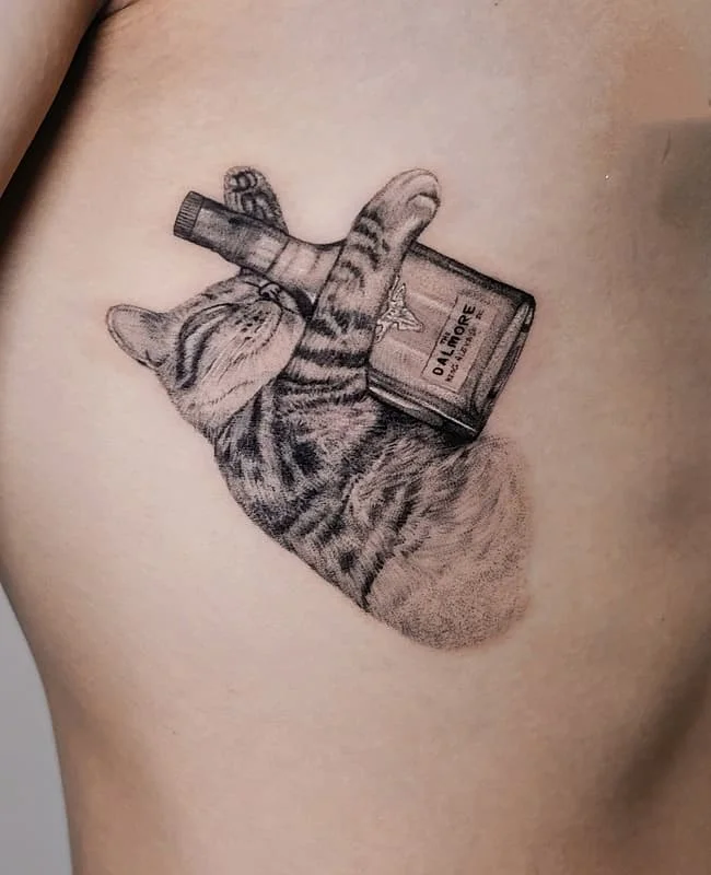 Realistic tattoo of a cat holding a whiskey bottle on rib.