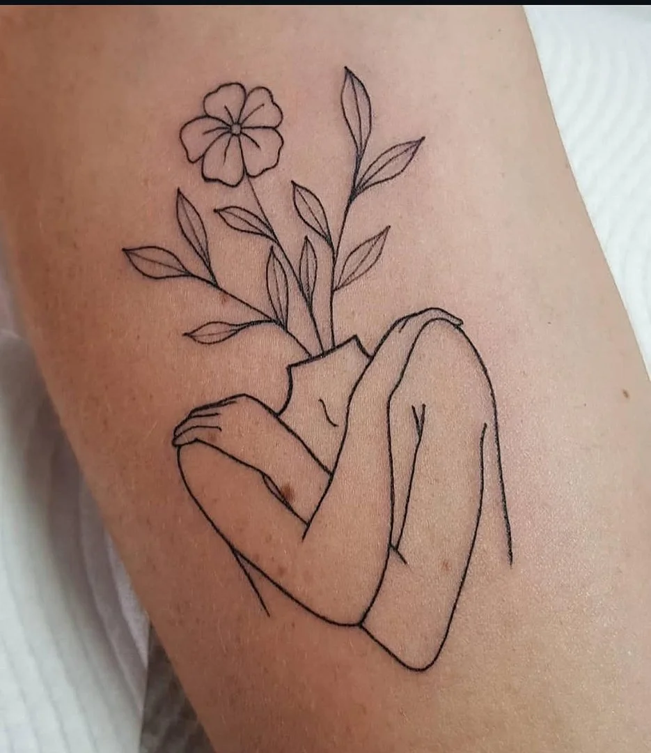 Fine-line tattoo of a headless figure with flowers on arm.