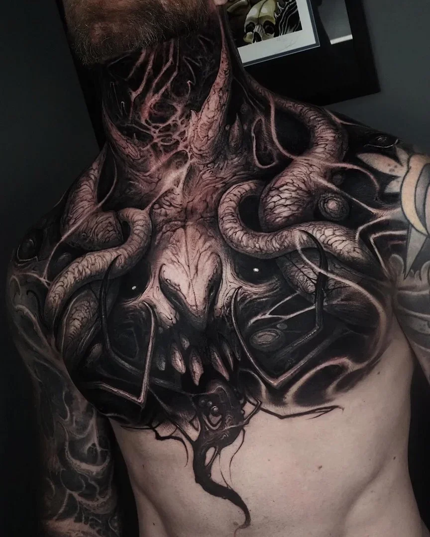 Large black-and-grey chest tattoo with tentacles and dark art.