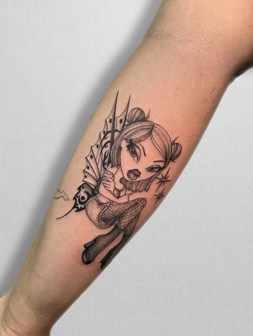 Illustrative black and grey fairy tattoo on forearm.
