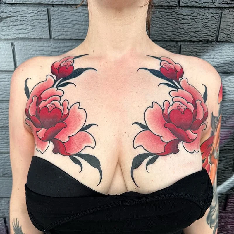 Large chest tattoo of red roses with black detailing.