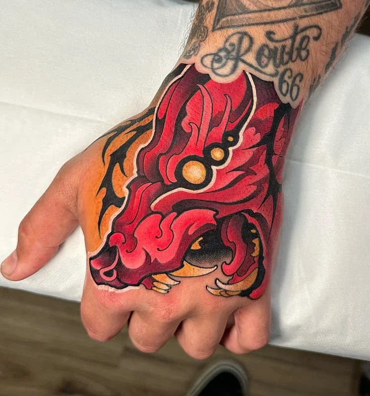 Vibrant dragon tattoo on a hand.
