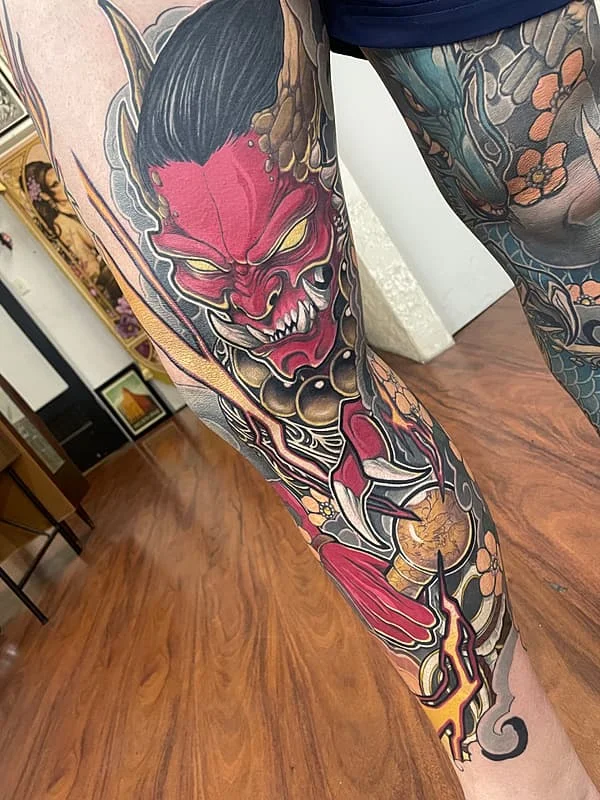 Vibrant leg tattoo of a demon with armor.