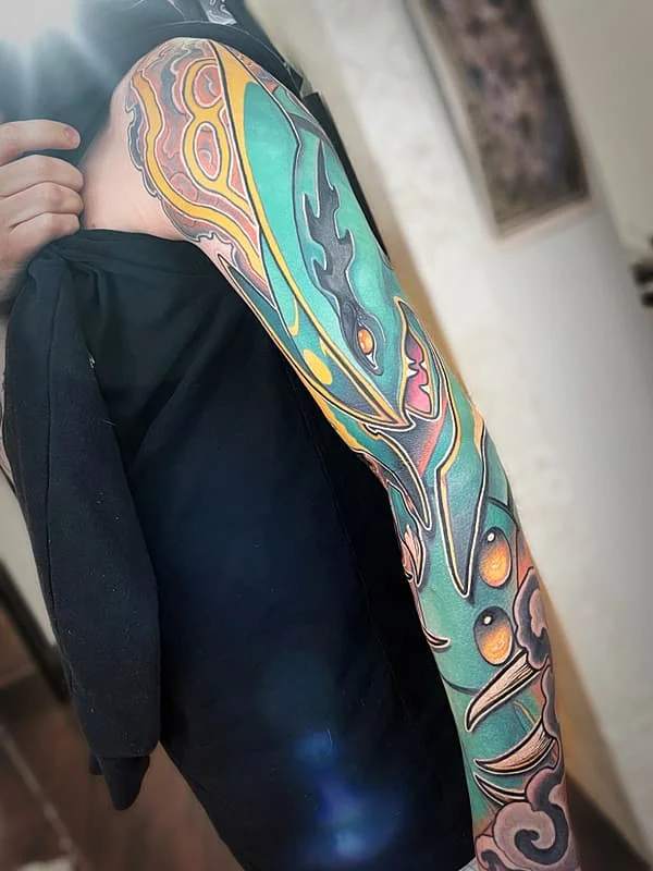 Vibrant dragon full-sleeve tattoo on arm.