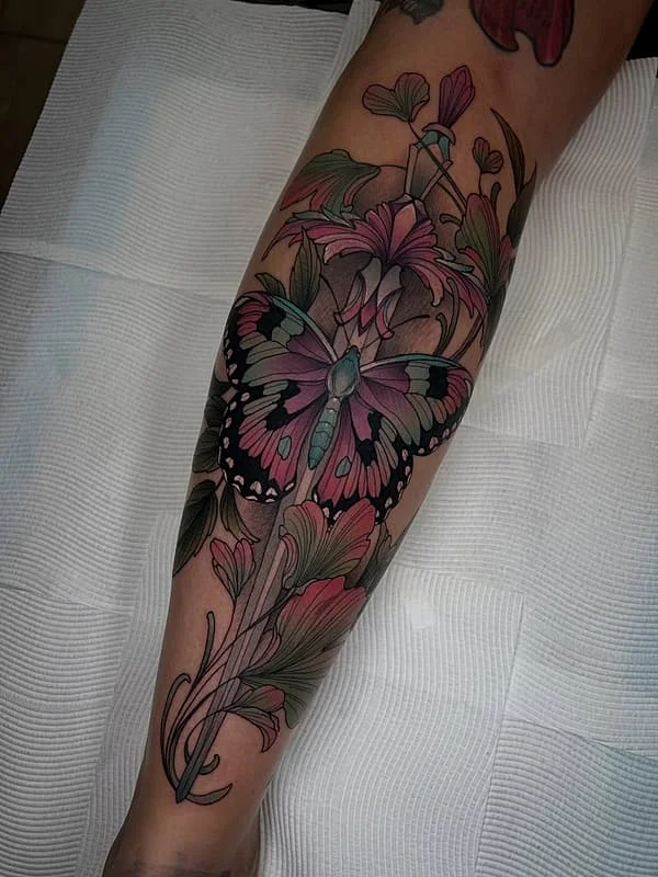 Colorful butterfly and flower tattoo on leg.