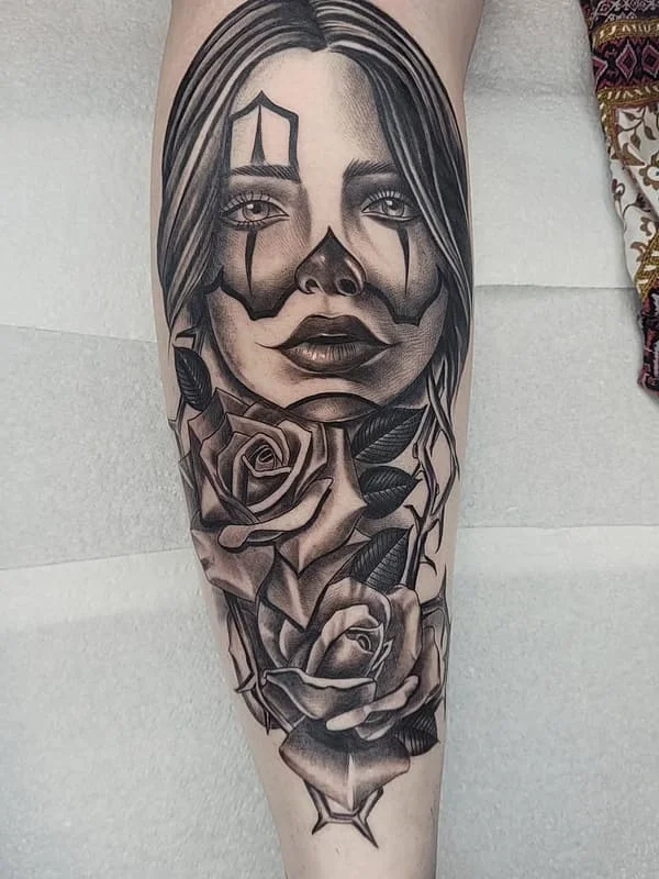 Realistic black-and-grey tattoo of a woman with roses.