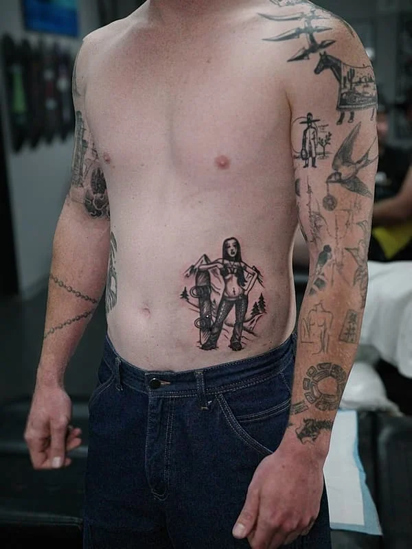 Medium black-grey illustrative tattoo of a woman on rib.