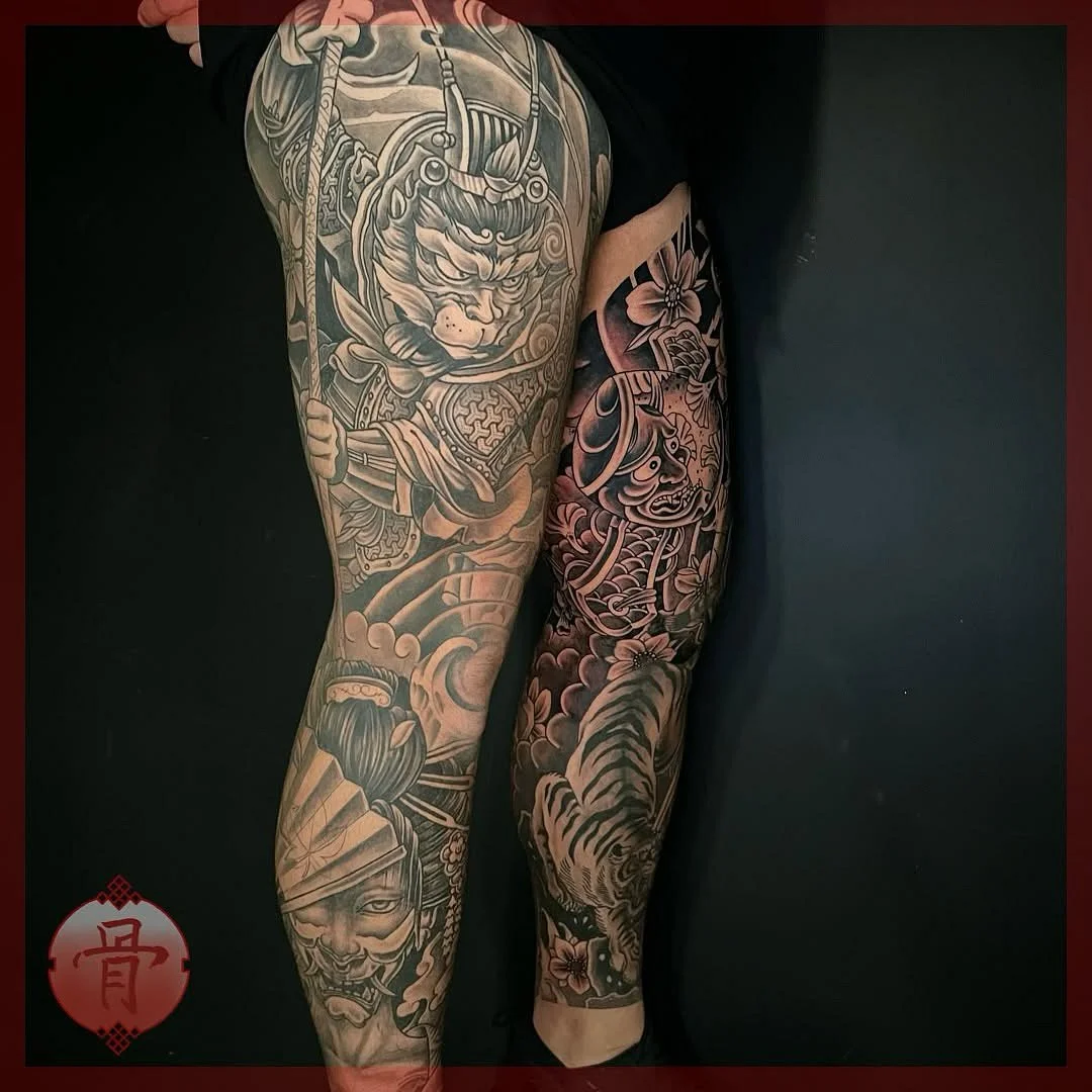 Large Japanese tattoo on leg featuring a warrior and tiger.