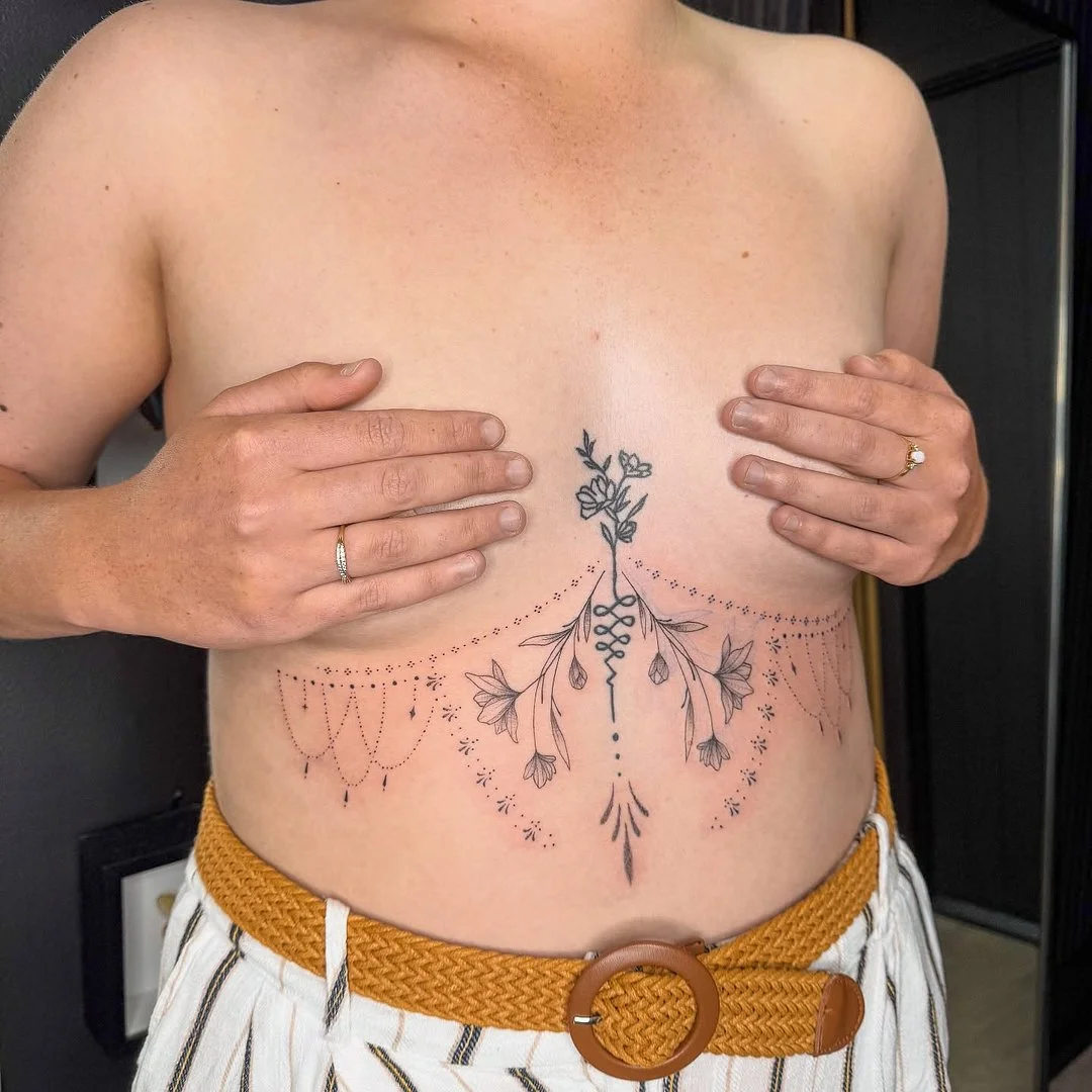 Delicate floral tattoo on chest and rib area.
