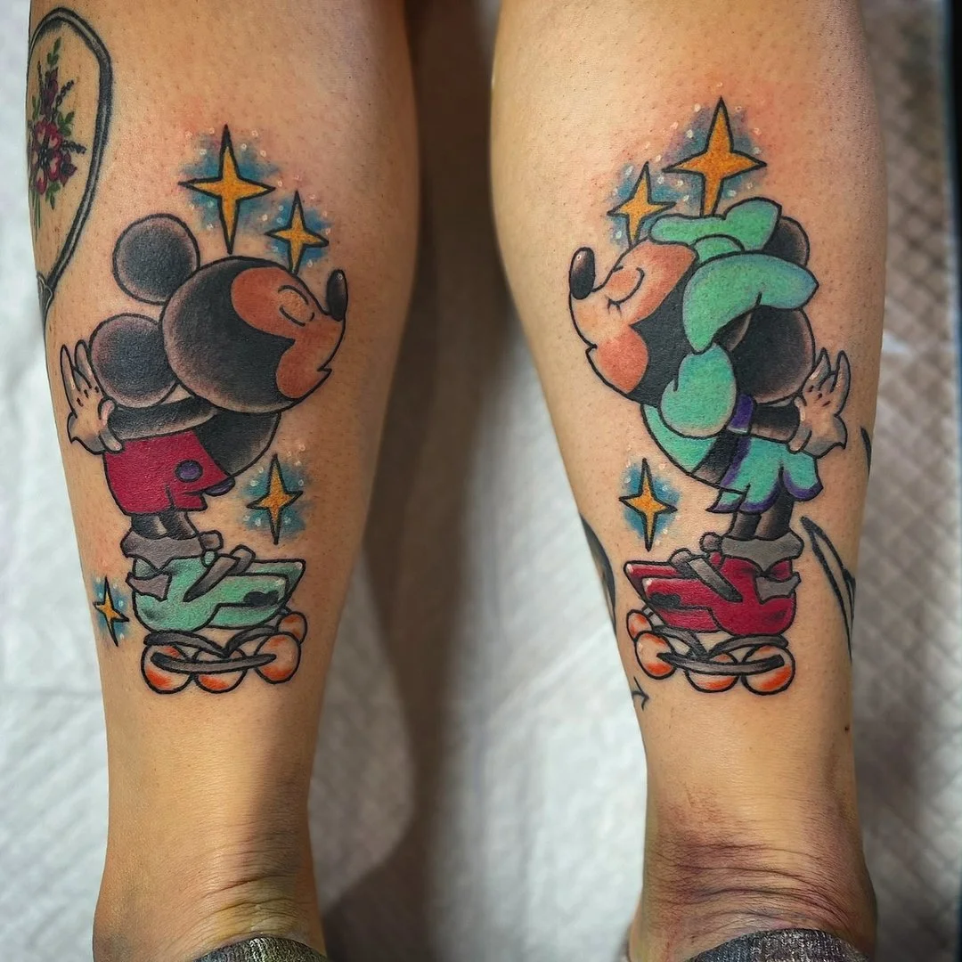 Colorful tattoo of Mickey Mouse and Goofy on calf.