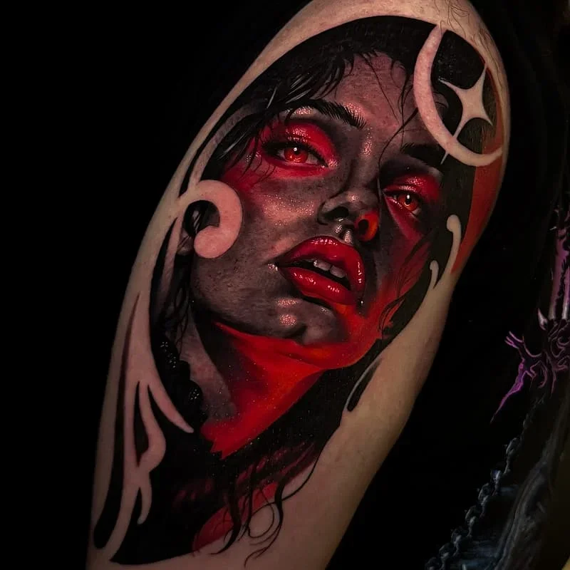Realism portrait tattoo with red accents on arm