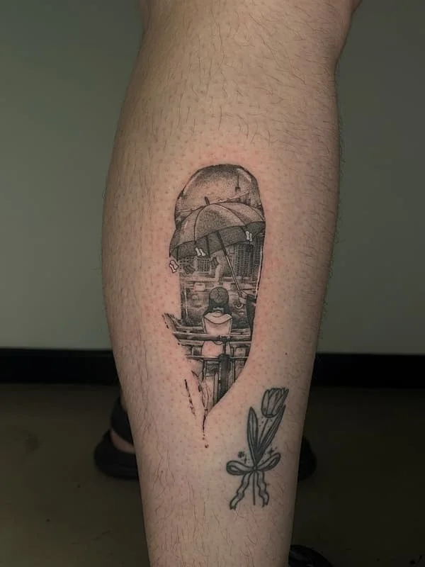 Black-and-grey tattoo of a girl with an umbrella on leg.