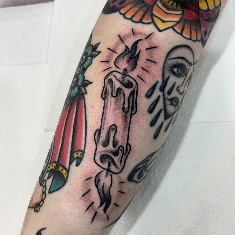 Traditional candle tattoo on forearm with black outlines.