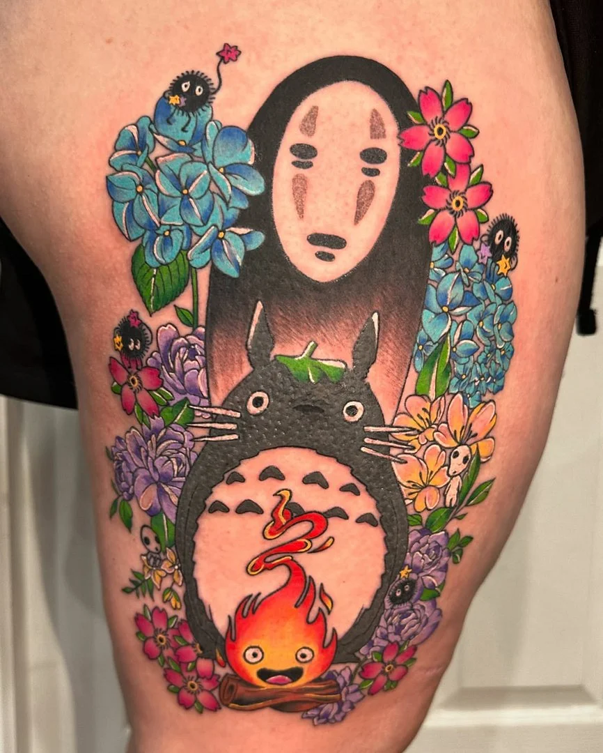 Colorful thigh tattoo featuring anime characters and flowers.