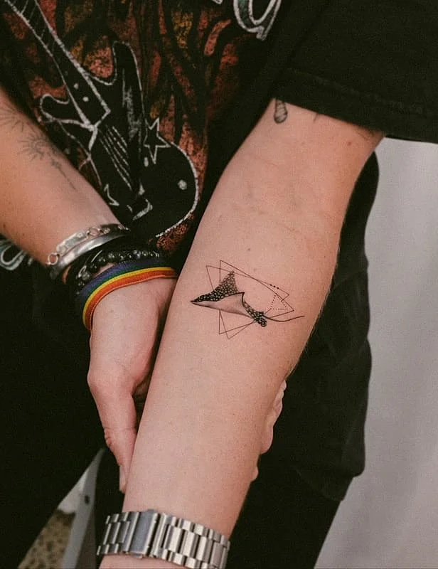 Geometric fine-line tattoo on forearm.