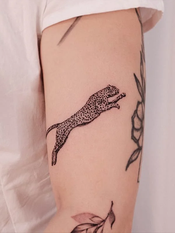 Illustrative blackwork leopard tattoo on arm.