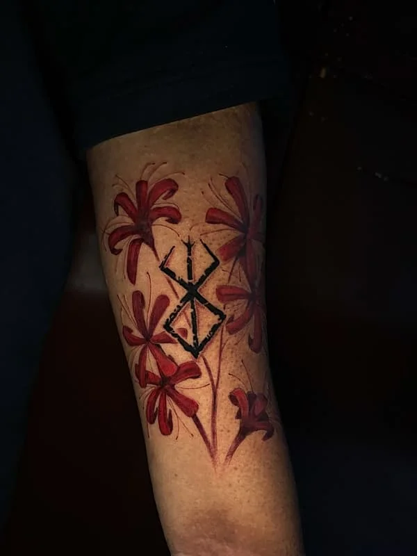 Colorful watercolor flower tattoo on forearm.