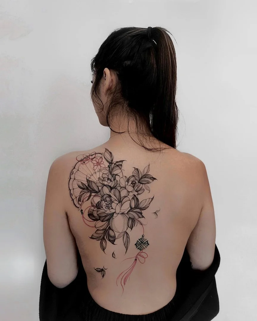 Large illustrative floral tattoo on a woman's back.